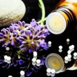 Lavender flowers with herbal homeopathy on a reflective surface, ideal for natural therapy themes.